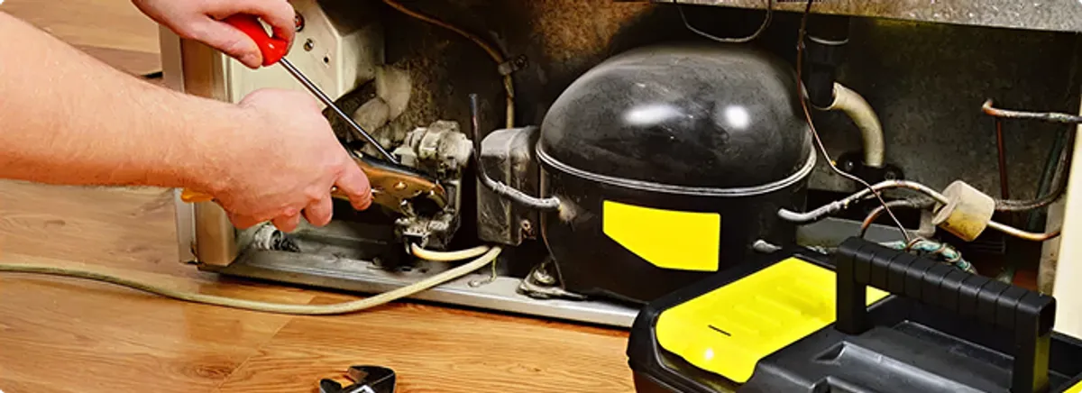 Refrigerator repair technician fixing the compressor and wiring in Truckee, CA