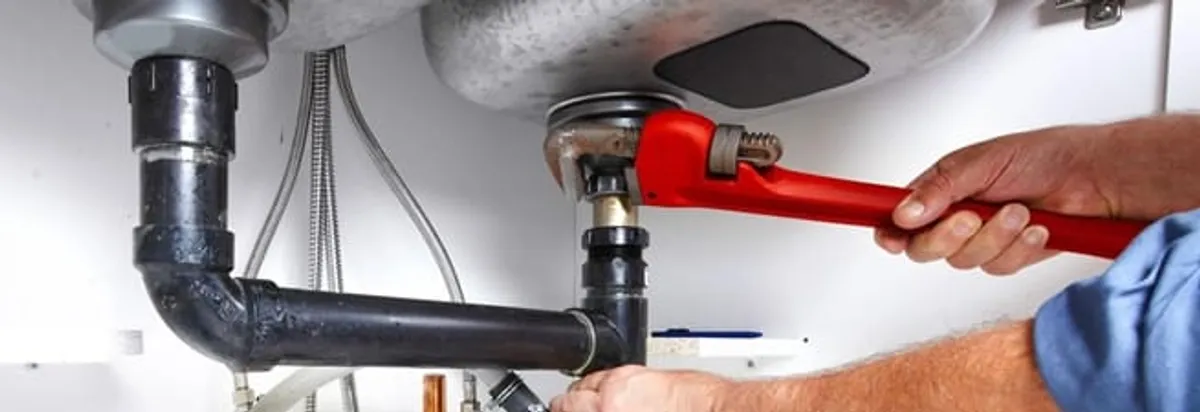 Garbage disposal repair technician tightening the sink drain and disposal connection in Reno, NV