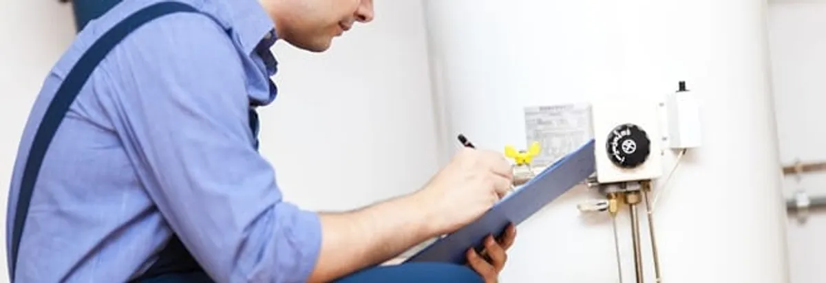 Water heater repair technician inspecting the unit and recording service notes in Reno, NV